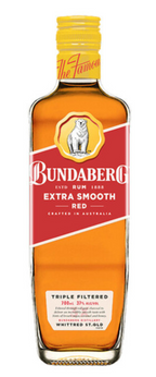 A Bundaberg rum bottle stands upright on a white background, amber liquid visible through glass; red-and-white label faces forward. Text on label: "BUNDABERG" and "EXTRA SMOOTH" (small print unreadable).