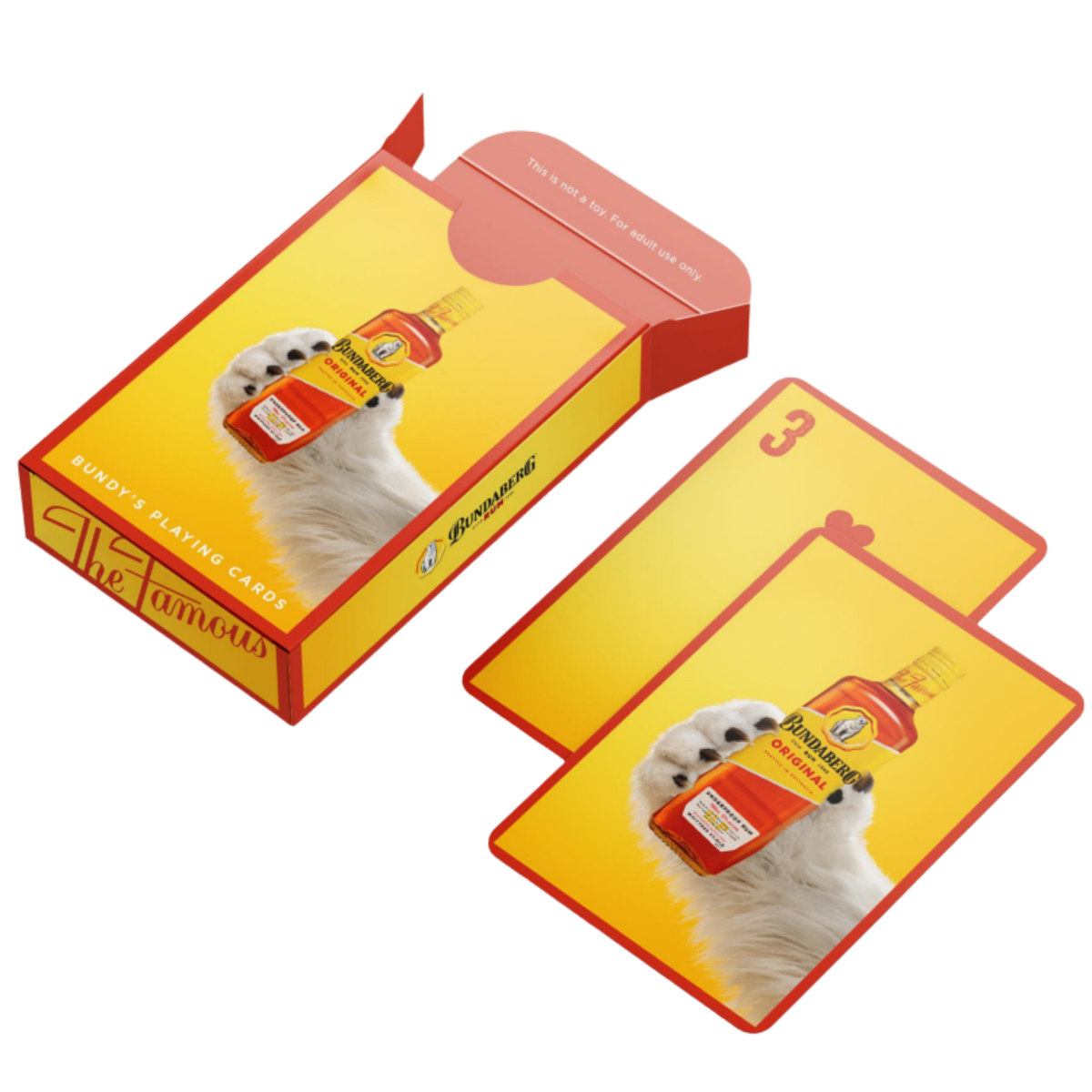 A yellow-orange card deck box sits open, showing two cards; each depicts a white fluffy dog balancing a hot-sauce bottle on its head against a yellow backdrop. No legible text.