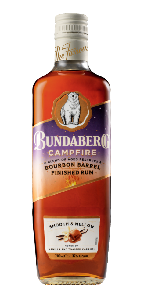 A tall glass bottle of Bundaberg Campfire rum stands upright on a white background, amber liquid visible through the bottle, purple-and-gold label with a polar-bear emblem.