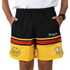 Black-and-yellow athletic shorts with red stripes, worn by a person standing with hands in pockets and a white T‑shirt visible.