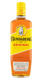 Glass bottle of Bundaberg Original rum stands upright against a plain white background; amber liquid visible, yellow diagonal label with polar bear logo and red "ORIGINAL" band.