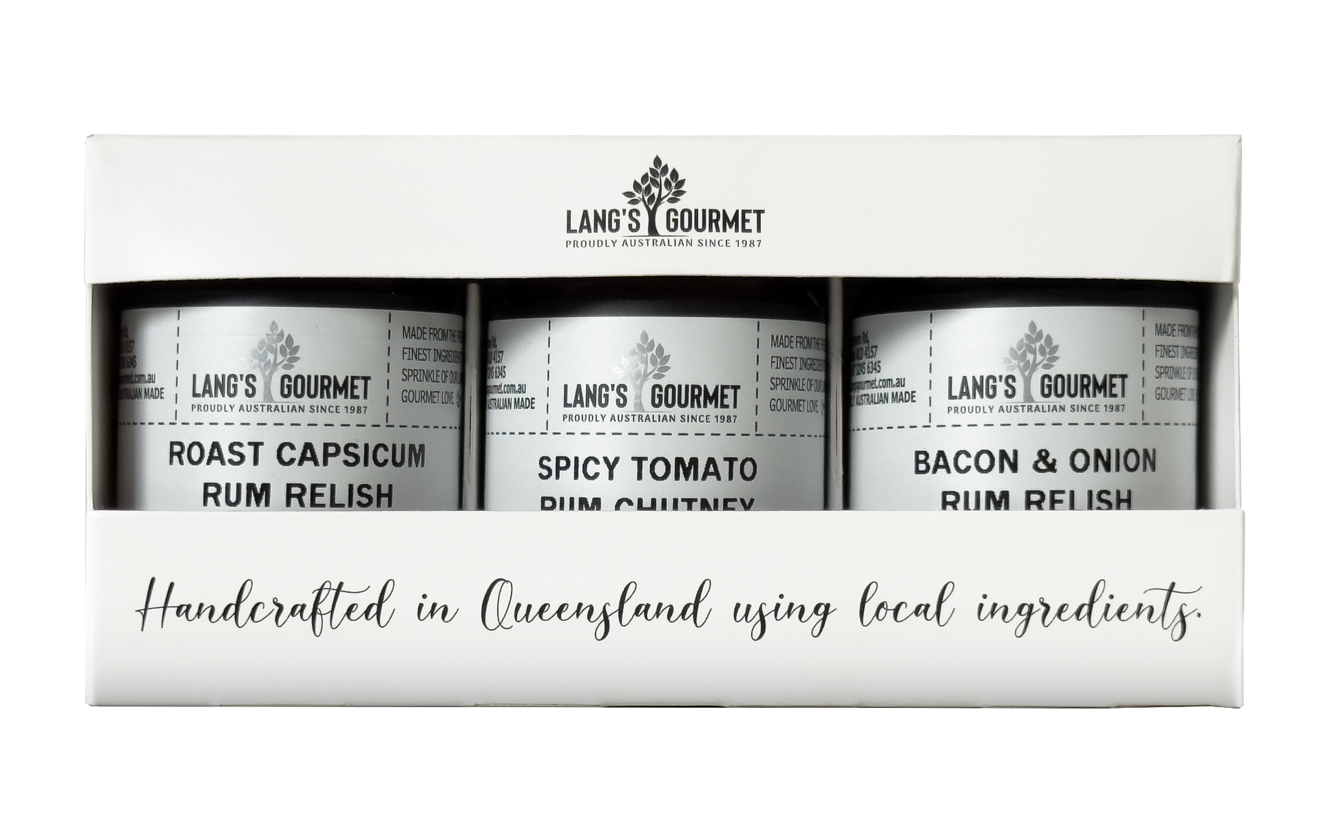 White gift box with three small jars visible through a front window; each jar shows a gourmet relish label; box sits on a plain white background.