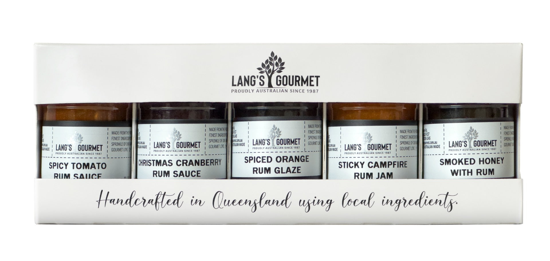 A boxed set of six small glass jars lined side-by-side behind a clear window, labeled preserves, staged in a white rectangular package on a white background.