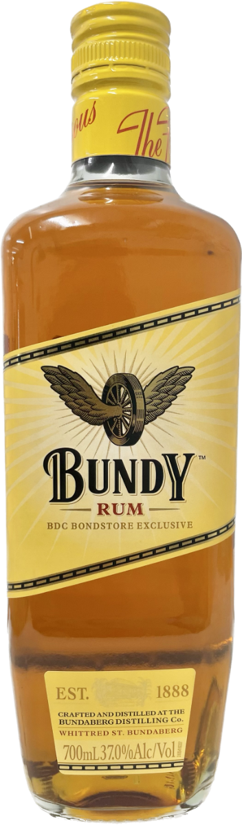 A tall glass bottle of amber Bundy Rum stands upright; the labeled bottle displays a diagonal yellow band with an eagle emblem, photographed against a plain white background.