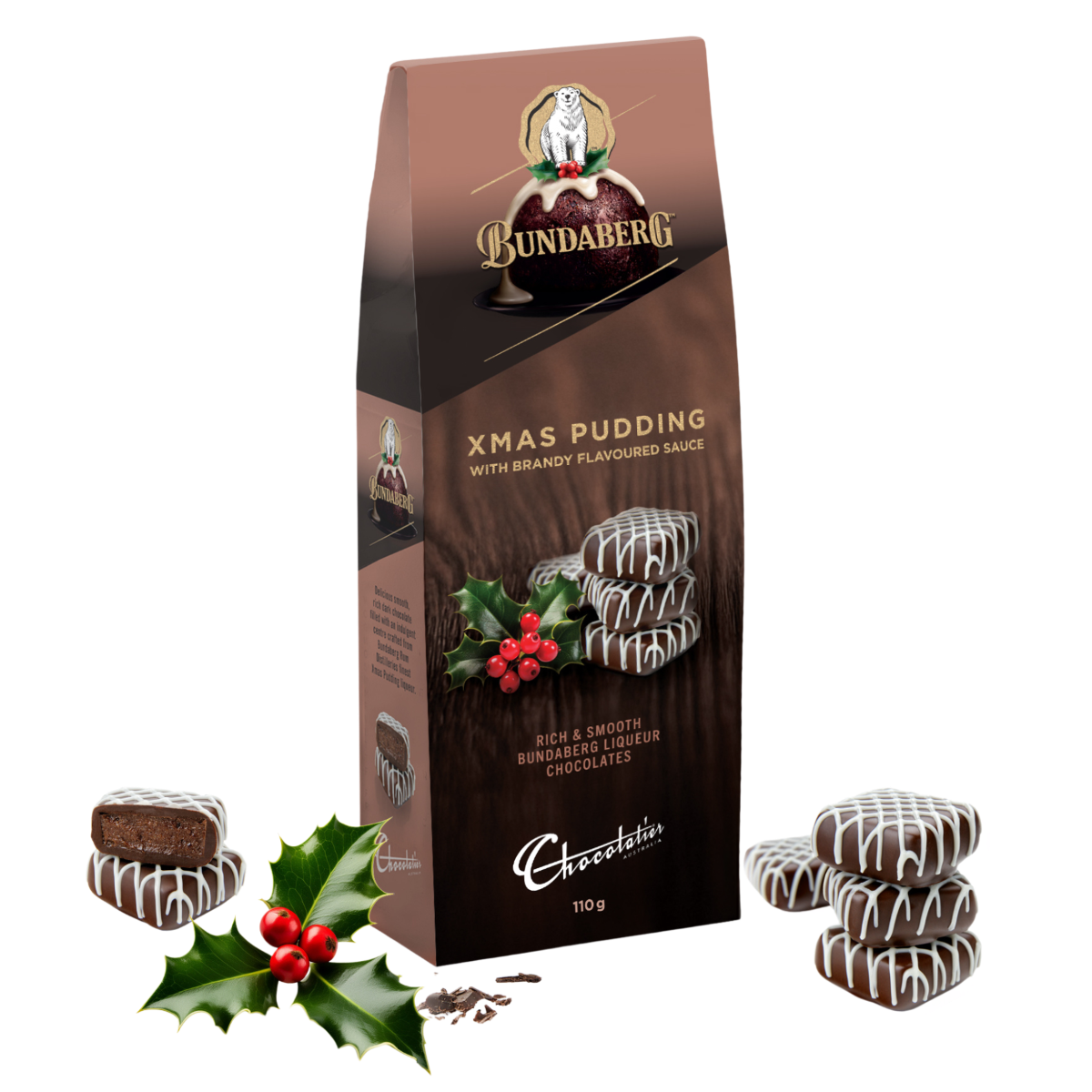 Tall brown carton of festive chocolates, surrounded by three white-drizzled chocolate cookies and holly, sitting on a plain white background.